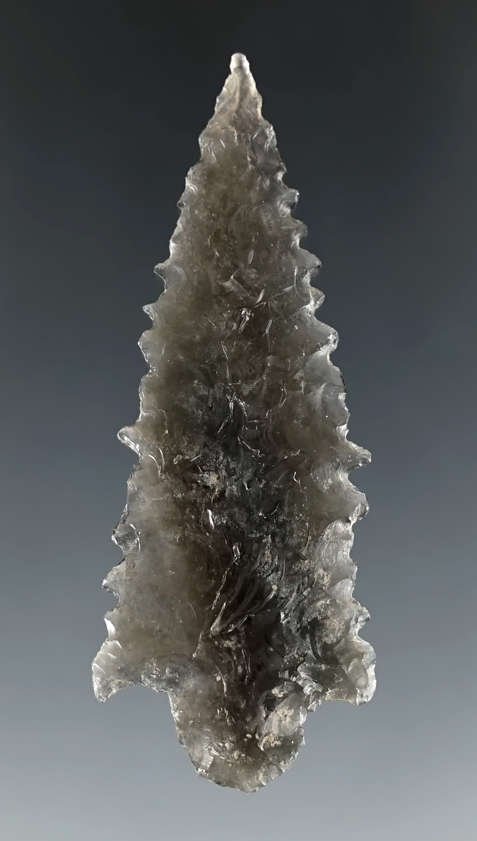 Thin and well made 2 1/4" serrated Stemmed point made from Obsidian. Great Basin area.